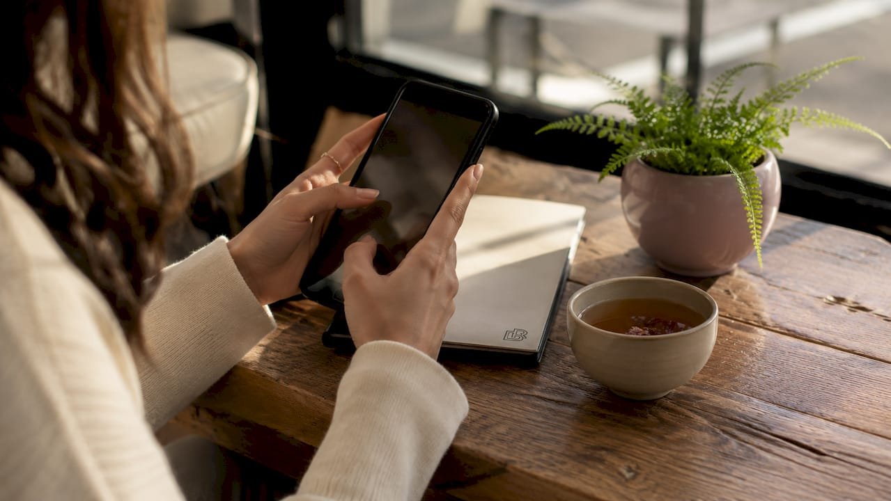 Close-up of hands booking beauty appointment on phone