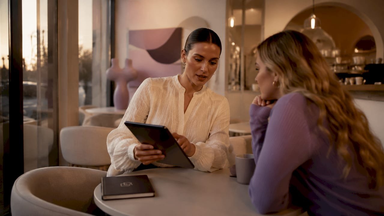 Beauty studio assistant managing client booking tablet